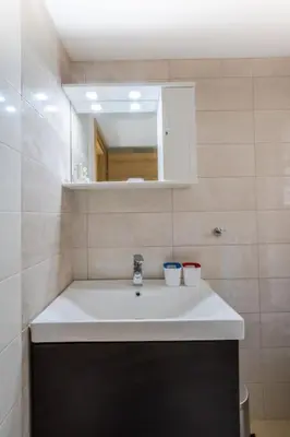 a bathroom with a white sink and a mirror at A modern and spacious flat in Gazi in Athens