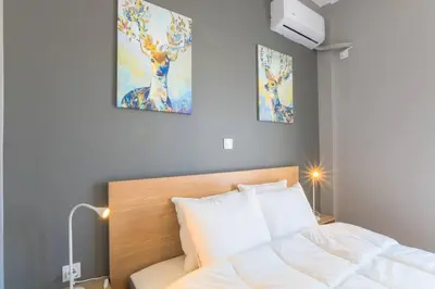 a bedroom with a bed and two paintings on the wall at A modern and spacious flat in Gazi in Athens