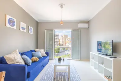 a living room with a blue couch and a table at A modern and spacious flat in Gazi in Athens