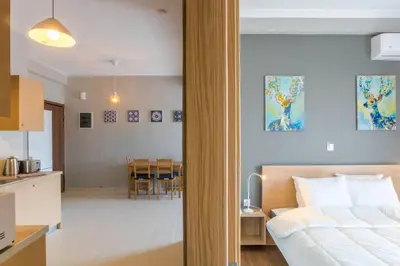 a bedroom with a bed and a kitchen and a dining room at A modern and spacious flat in Gazi in Athens