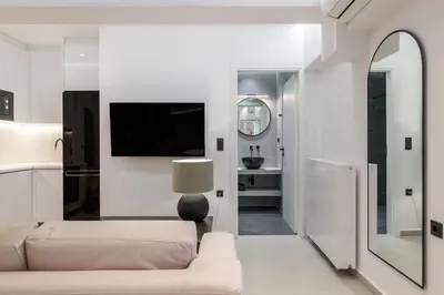 a living room with a couch and a tv at Loom Suite Downtown Athens in Athens