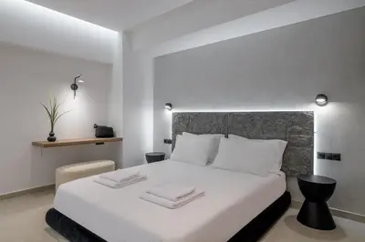 a bedroom with a large white bed with white pillows at Loom Suite Downtown Athens in Athens