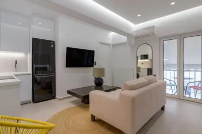 a white living room with a couch and a table at Loom Suite Downtown Athens in Athens