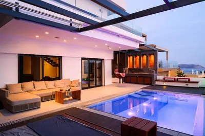 a swimming pool in a house with a couch and a couch at Athens riviera beach villa in Anavissos