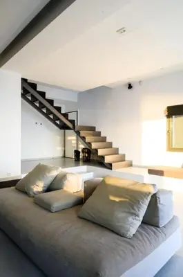 a living room with a bed with pillows and stairs at Athens riviera beach villa in Anavissos
