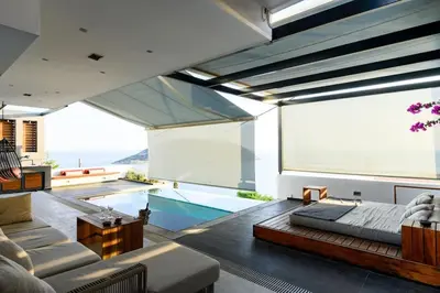 a living room with a large window and a swimming pool at Athens riviera beach villa in Anavissos
