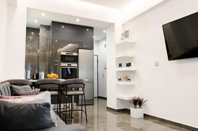 a living room with a bar with stools and a television at Larissa Railway &Metro station apartment in Athens