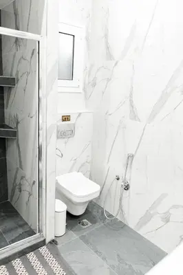 a white bathroom with a toilet and a shower at Larissa Railway &Metro station apartment in Athens