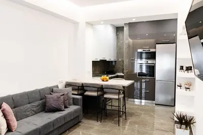 a living room with a couch and a kitchen at Larissa Railway &Metro station apartment in Athens