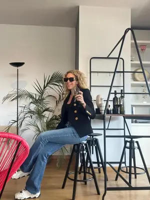 a woman sitting on a chair in a kitchen at Herodion Residence in Athens