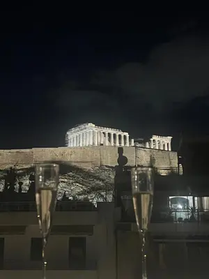 two glasses of champagne in front of a building at Herodion Residence in Athens