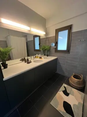 a bathroom with a large sink and a large mirror at Herodion Residence in Athens