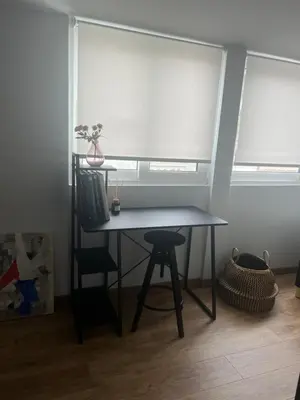 a table and a chair in a room with a window at Herodion Residence in Athens