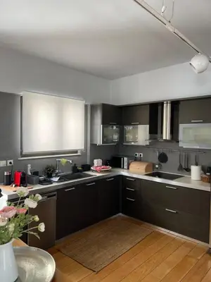 a large kitchen with black cabinets and a table at Herodion Residence in Athens