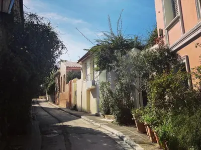 an empty street with buildings and plants on the side at Herodion Residence in Athens