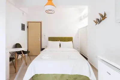 a bedroom with a large white bed in a room at Cosy studio in the Petralona neighbourhood in Athens