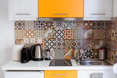a kitchen with a sink and a tiled wall at Cosy studio in the Petralona neighbourhood in Athens