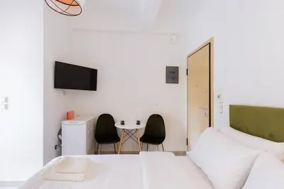 a bedroom with a bed and a table with chairs at Cosy studio in the Petralona neighbourhood in Athens