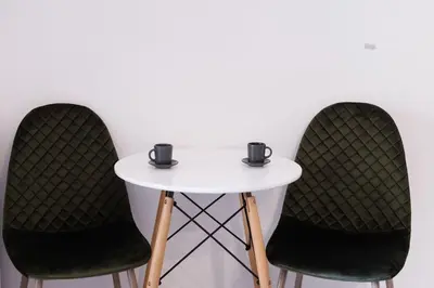 two chairs and a white table with two cups on it at Cosy studio in the Petralona neighbourhood in Athens