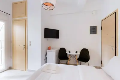 a bedroom with a bed and two chairs and a table at Cosy studio in the Petralona neighbourhood in Athens