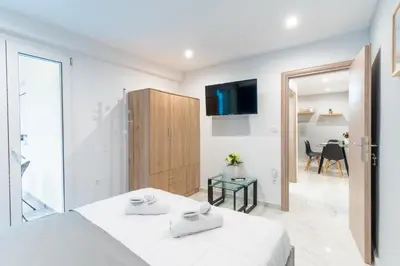 a white bedroom with a bed and a sliding glass door at elegant escapes 2 nea smyrni in Athens