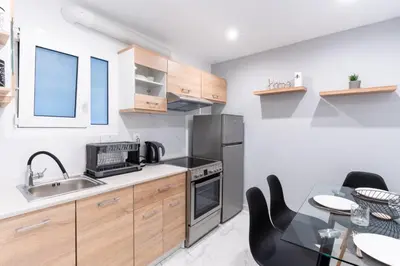 a kitchen with a sink and a table with chairs at elegant escapes 2 nea smyrni in Athens