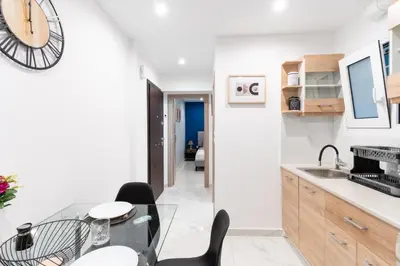 a kitchen with a glass table and a clock on the wall at elegant escapes 2 nea smyrni in Athens