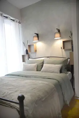 a bedroom with a large bed with two lamps at Hara's Apartment in Athens