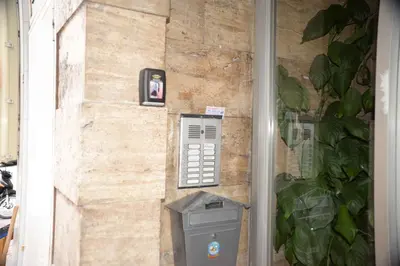 a brick wall with a pay phone and a trash can at Hara's Apartment in Athens