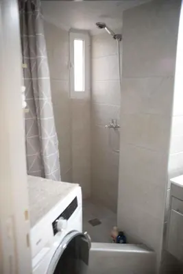 a bathroom with a shower and a washing machine at Hara's Apartment in Athens