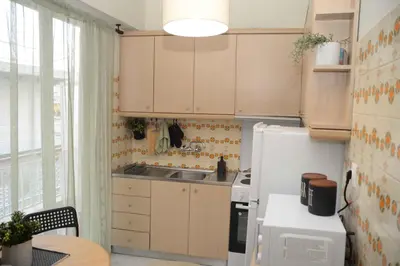 a kitchen with a white refrigerator and a sink at Hara's Apartment in Athens