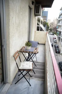a balcony with a table and chairs on a balcony at Hara's Apartment in Athens
