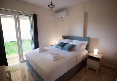 a bedroom with a white bed with a large window at Athens Acropolis View Penthouse-Center of Athens in Athens