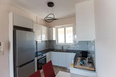 a kitchen with white cabinets and a stainless steel refrigerator at Athens Acropolis View Penthouse-Center of Athens in Athens