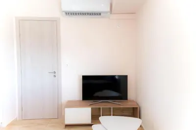 a living room with a television on a wooden stand at Athens Acropolis View Penthouse-Center of Athens in Athens