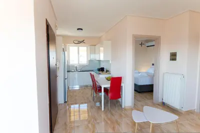 a kitchen and dining room with a table and red chairs at Athens Acropolis View Penthouse-Center of Athens in Athens