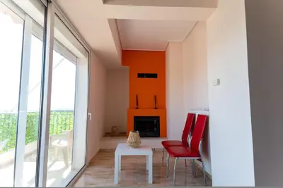 a living room with a red chair and a fireplace at Athens Acropolis View Penthouse-Center of Athens in Athens