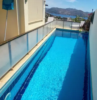 a swimming pool on the roof of a building with blue water at Τάνια in Anavissos
