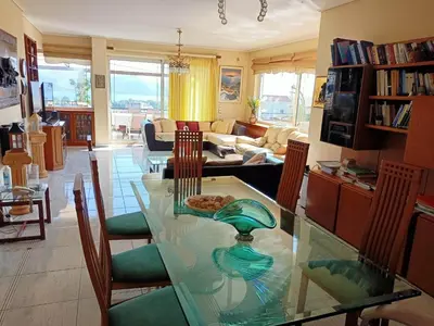 a living room with a glass table and chairs at Τάνια in Anavissos