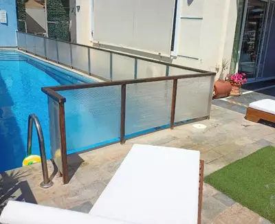 a metal railing next to a swimming pool at Τάνια in Anavissos