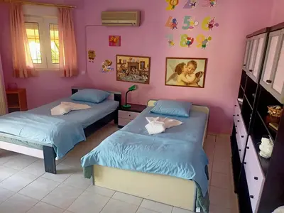 two beds in a room with pink walls at Τάνια in Anavissos