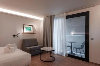 a hotel room with a bed and a chair and a table at Urban Frame Acropolis in Athens