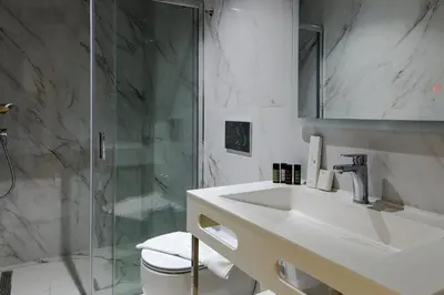 a bathroom with a sink and a glass shower at Urban Frame Acropolis in Athens