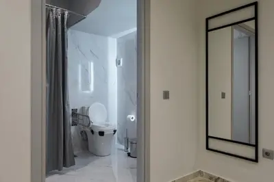 a white bathroom with a toilet and a mirror at Urban Frame Acropolis in Athens