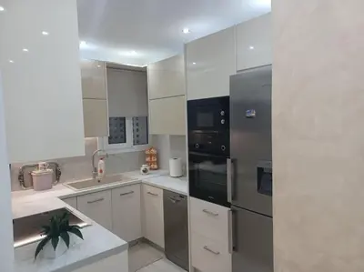 a kitchen with a stainless steel refrigerator and white cabinets at Cozy Renovated Apartment in Athens