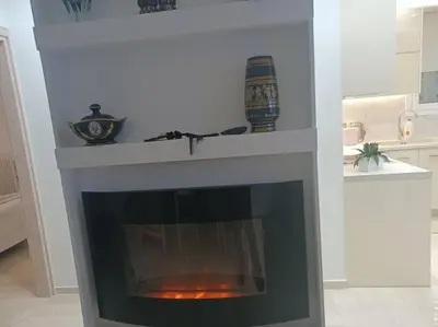 a fireplace in a living room with a white mantle at Cozy Renovated Apartment in Athens