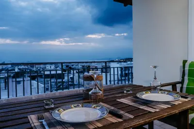 a wooden table with plates on top of a balcony at Penthouse of diamond in Athens