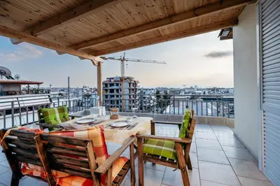 a patio with a table and chairs on a balcony at Penthouse of diamond in Athens