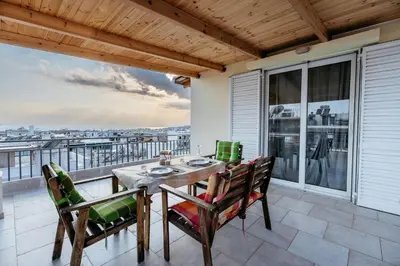 a patio with a table and chairs on a balcony at Penthouse of diamond in Athens
