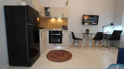 a kitchen with a refrigerator and a table with chairs at City Life Metro Ambelokipi in Athens
